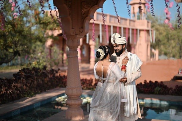 Romantic portrait of couple under pink mandap structure