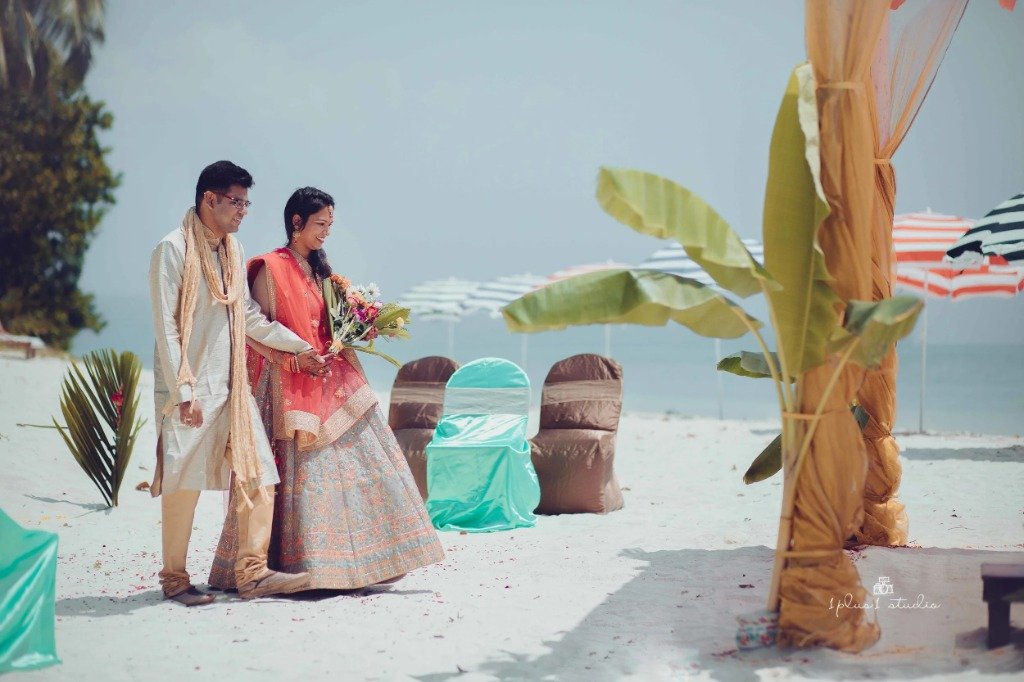 Couple walking on white sand beach wedding setup